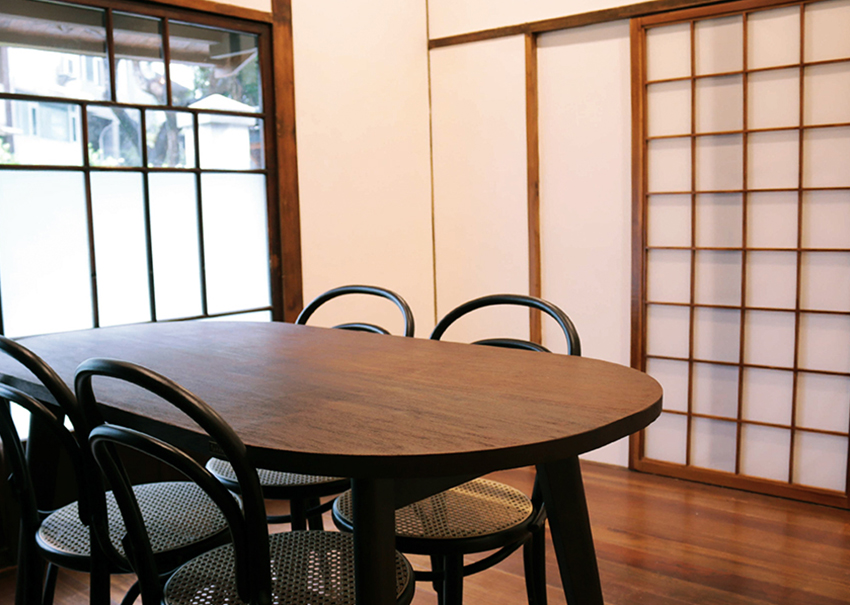 The dining room has a bookshelf, rectangular dining table, and four chairs.